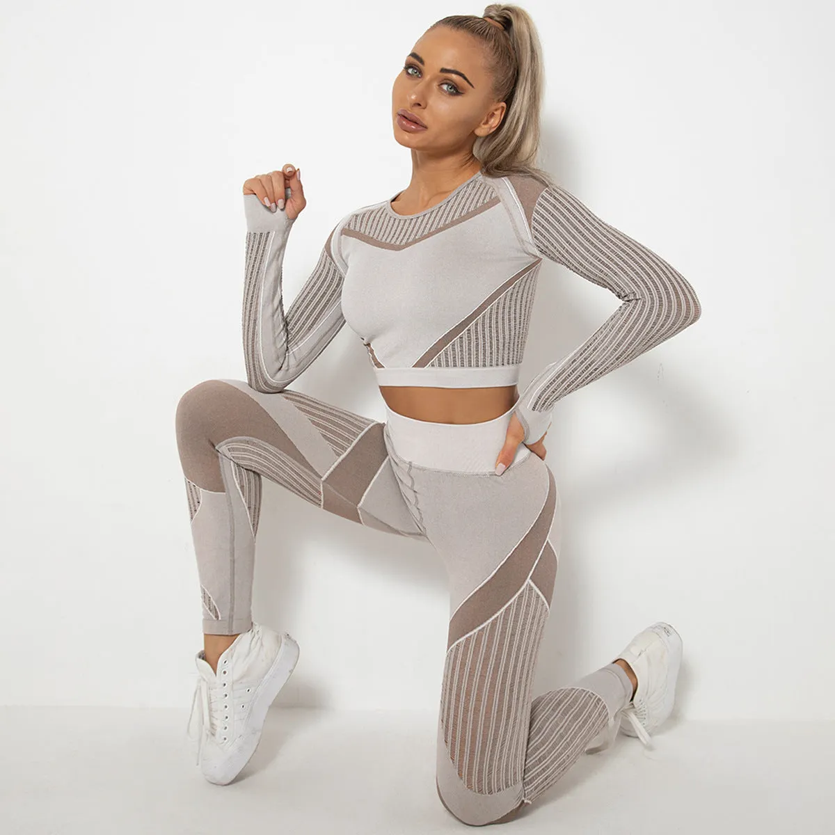 Woman wearing a seamless long-sleeved yoga suit in a neutral colour, demonstrating a stretch pose.
