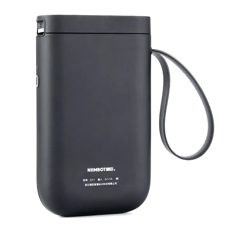 Compact black D11 Bluetooth thermal label printer on a desk next to a smartphone showing the label design app.