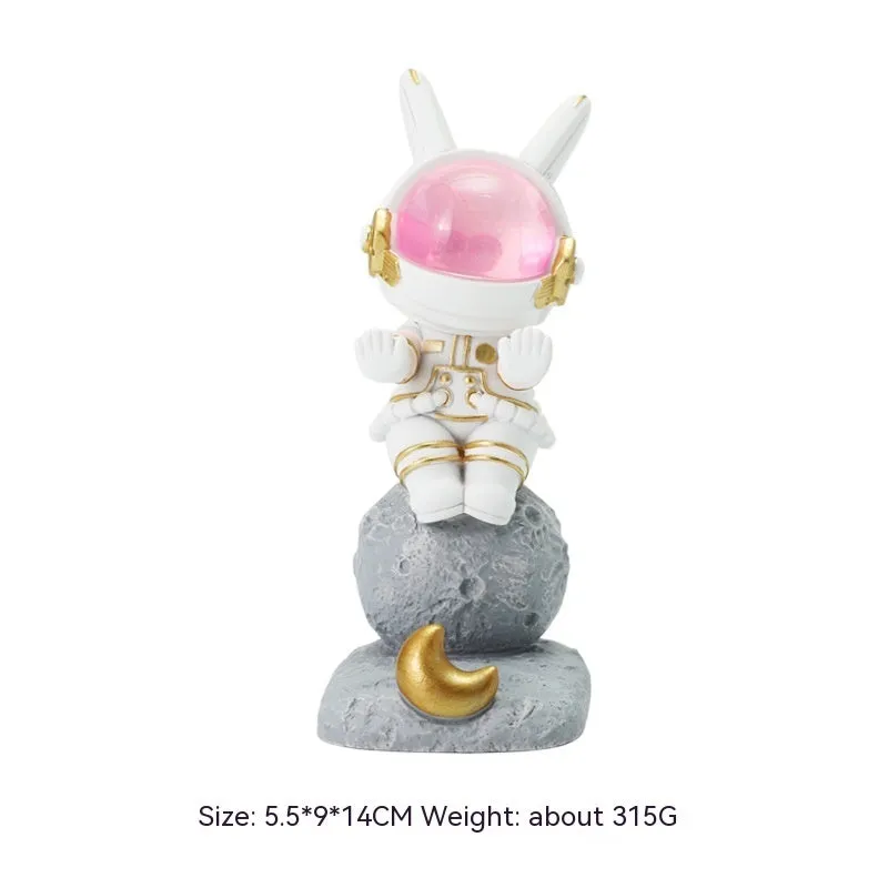 Space Rabbit resin phone stand in pink holding a smartphone on a desktop