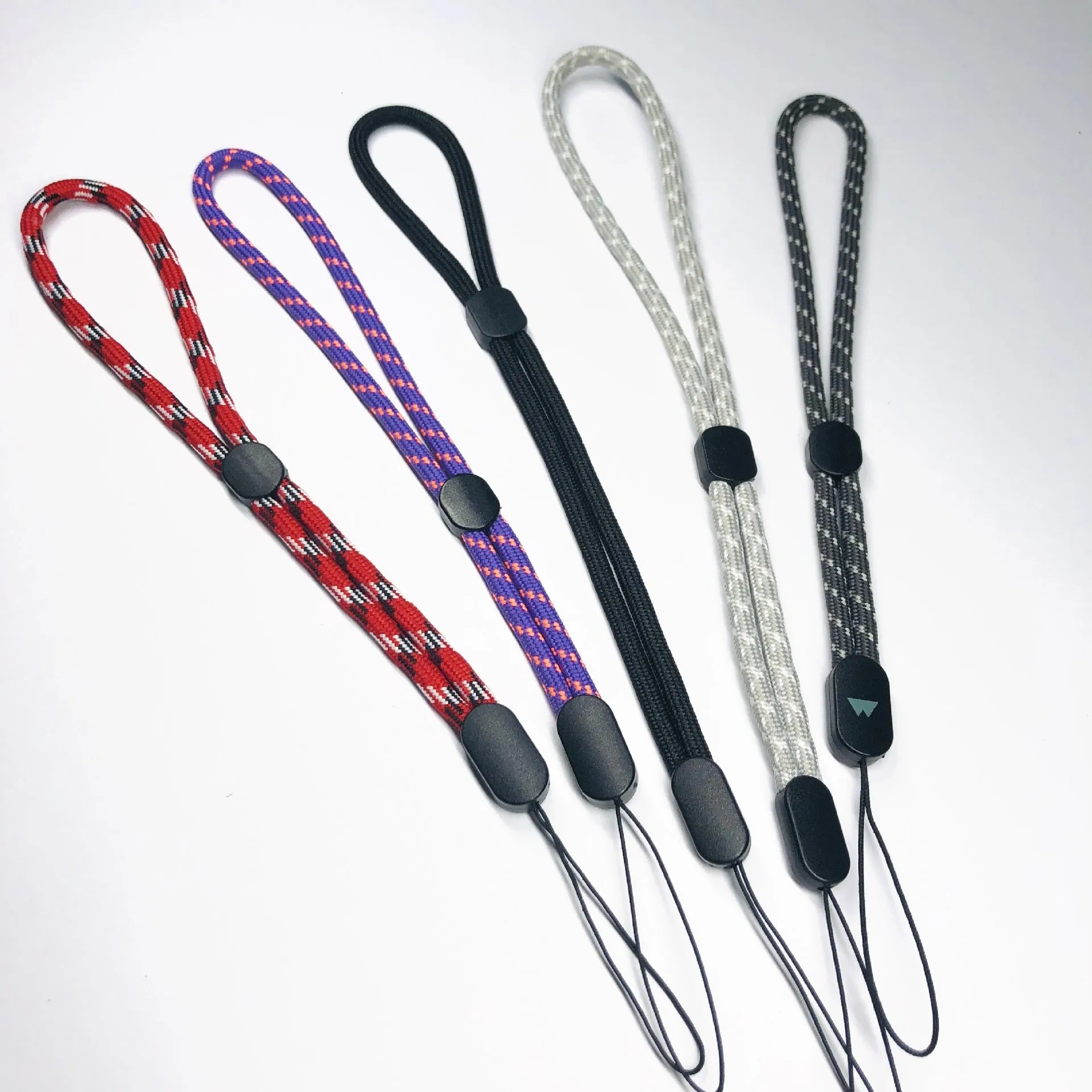 Adjustable round woven mobile phone lanyard in pink, white, and blue colours on a white background