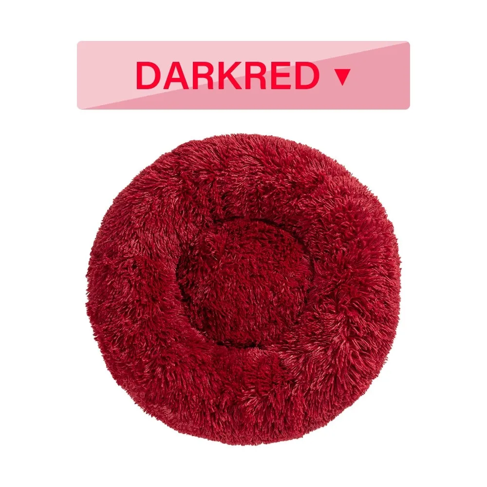 Fluffy donut-shaped pet bed in long plush fabric, showing raised rim, available in multiple colours.
