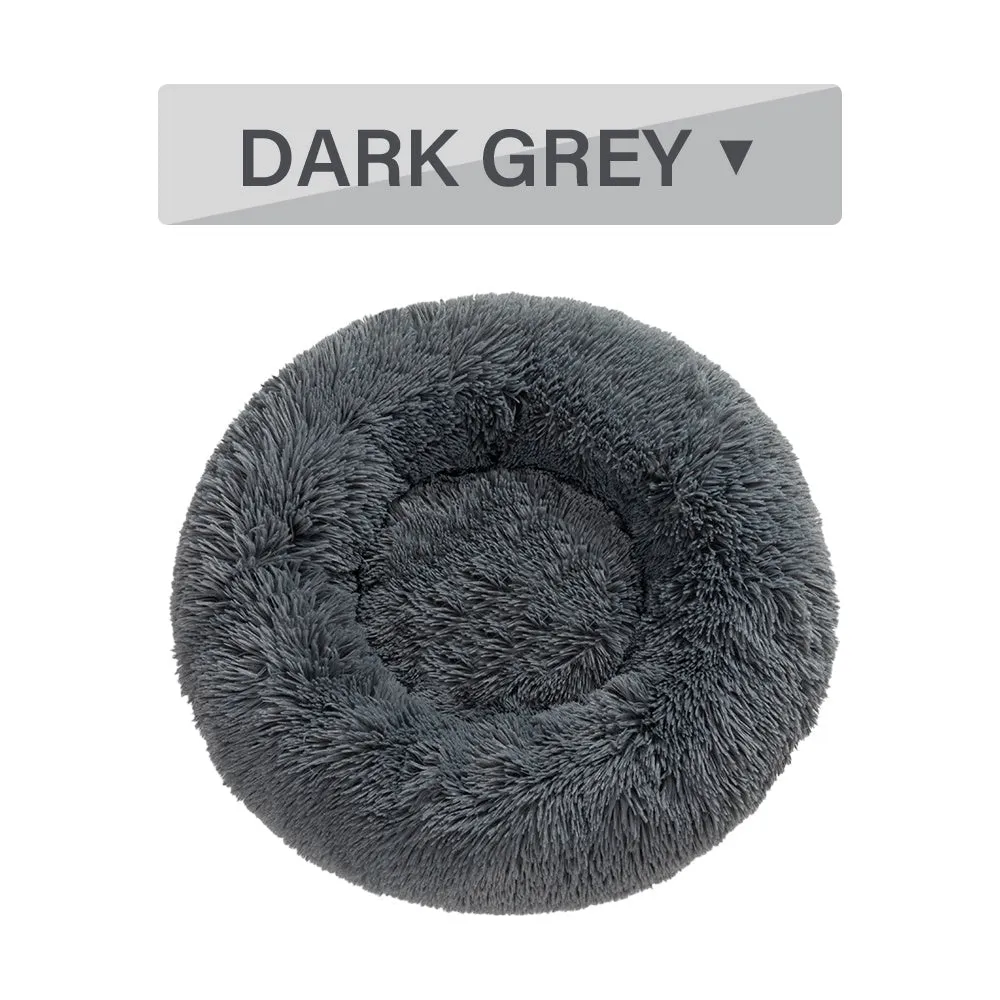 Fluffy donut-shaped pet bed in long plush fabric, showing raised rim, available in multiple colours.