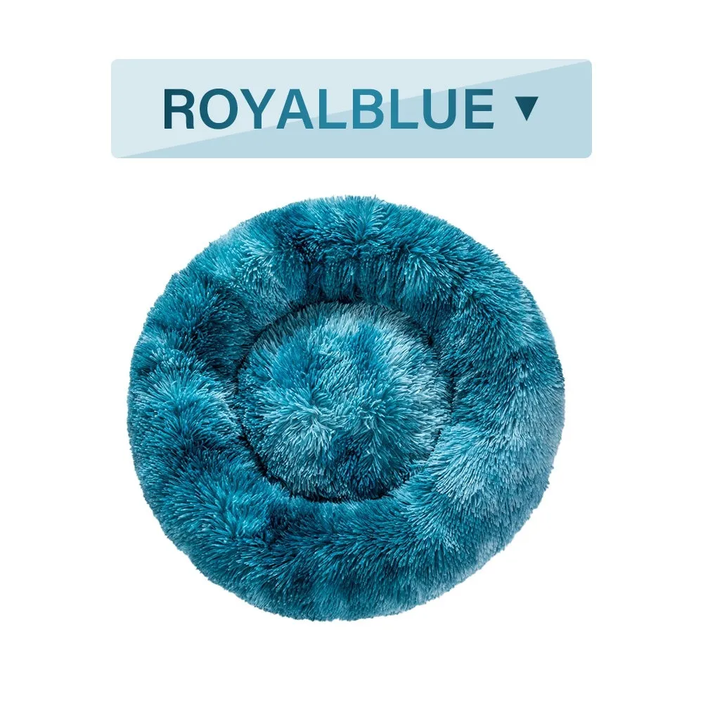 Fluffy donut-shaped pet bed in long plush fabric, showing raised rim, available in multiple colours.