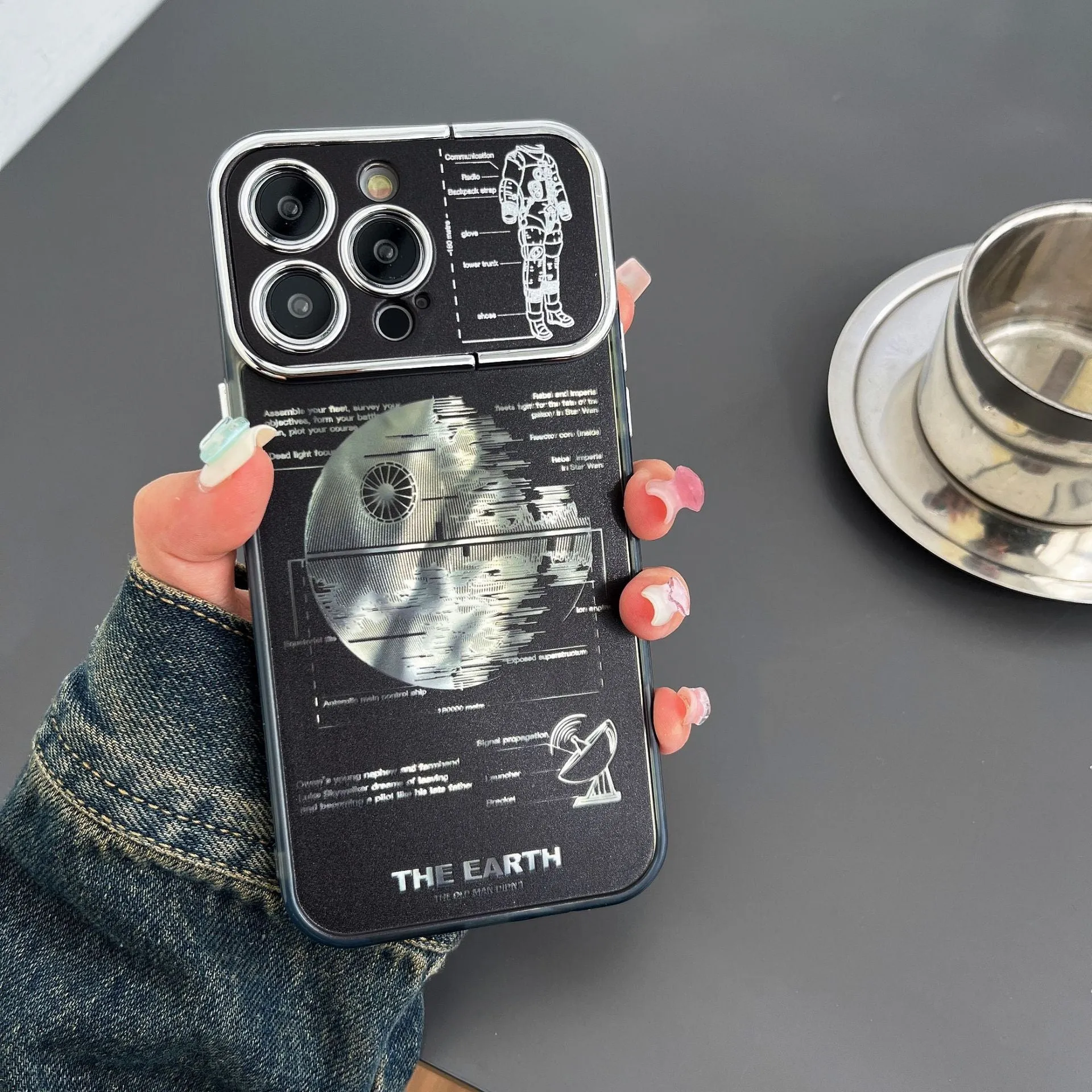 Pleated bracket TPU phone case with metal planet design for iPhone 14 Pro, two colour options shown