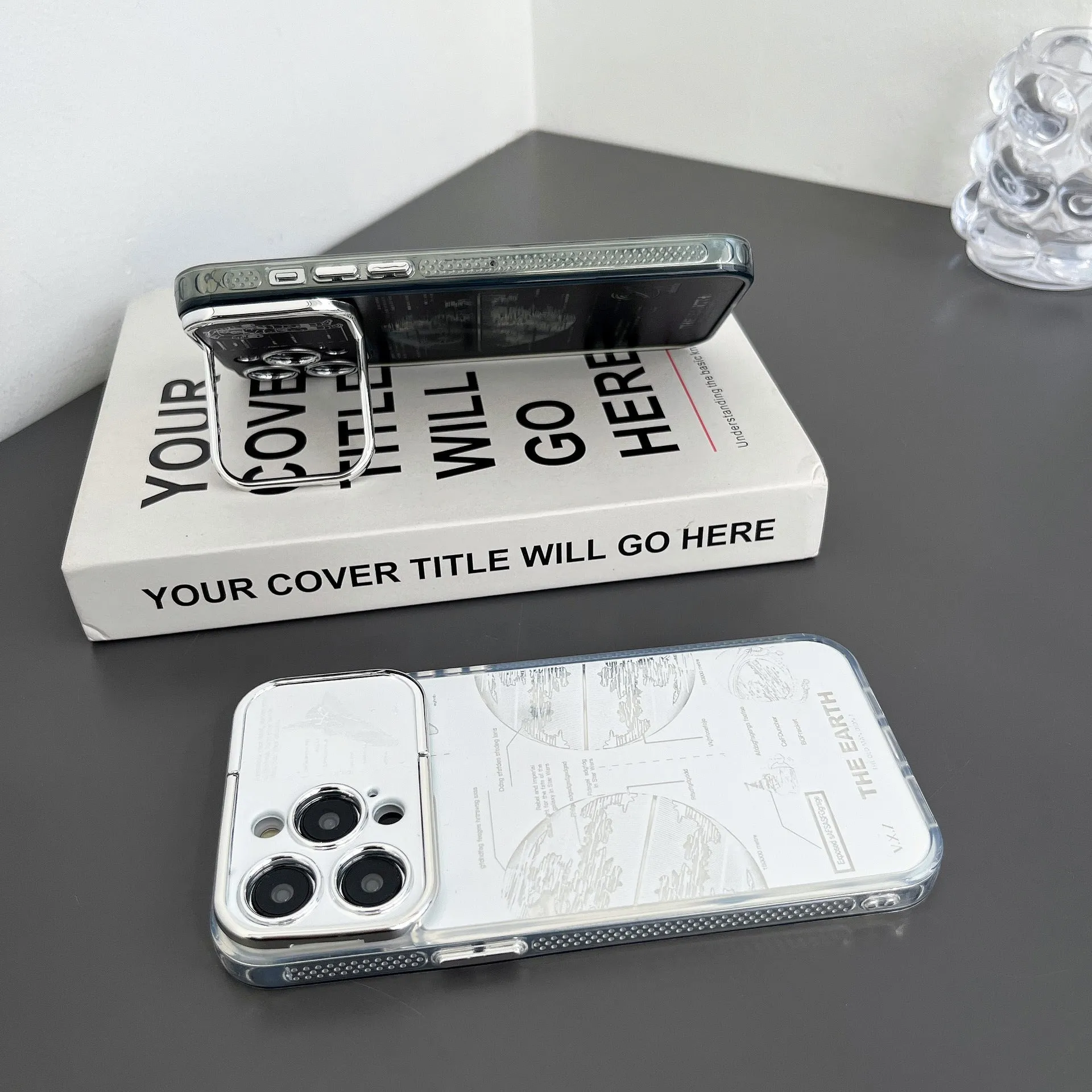 Pleated bracket TPU phone case with metal planet design for iPhone 14 Pro, two colour options shown