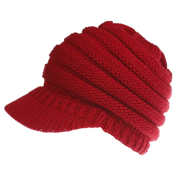 Acrylic knitted ponytail beanie hat for women in a neutral colour, shown on a model with a high ponytail.