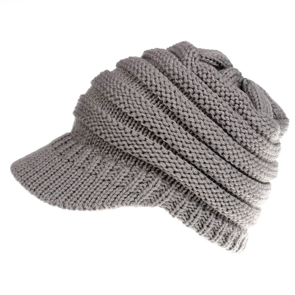 Acrylic knitted ponytail beanie hat for women in a neutral colour, shown on a model with a high ponytail.