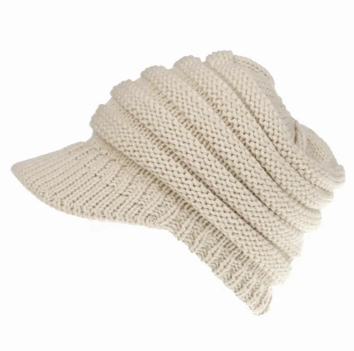 Acrylic knitted ponytail beanie hat for women in a neutral colour, shown on a model with a high ponytail.