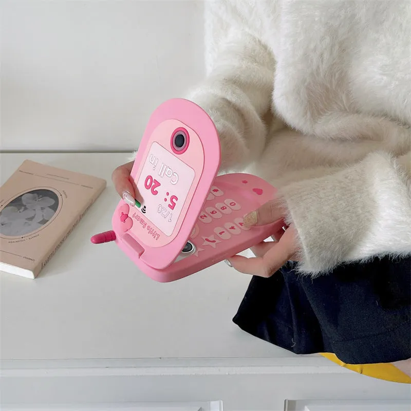 A light pink silicone iPhone case shaped like a flip phone with a built-in mirror on the front.