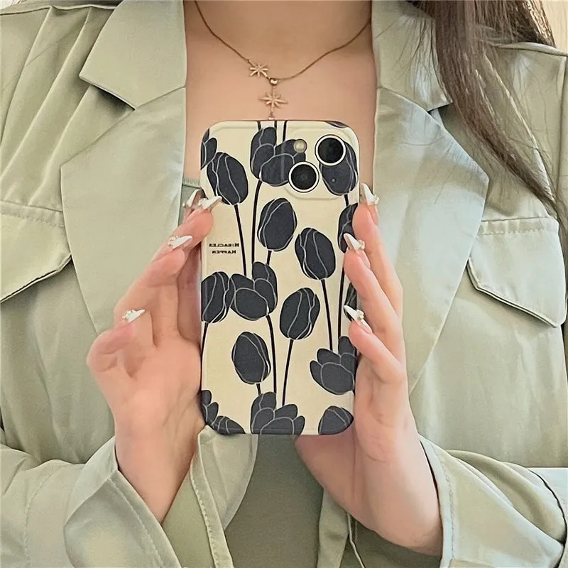 Black silicone iPhone case with a detailed tulip floral pattern on the back.