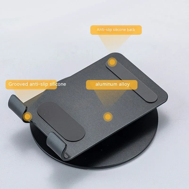 Grey aluminium alloy rotating mobile phone bracket on desk with silica gel grip, 4.8 x 4.2 x 1.4 cm, holding a smartphone in landscape mode