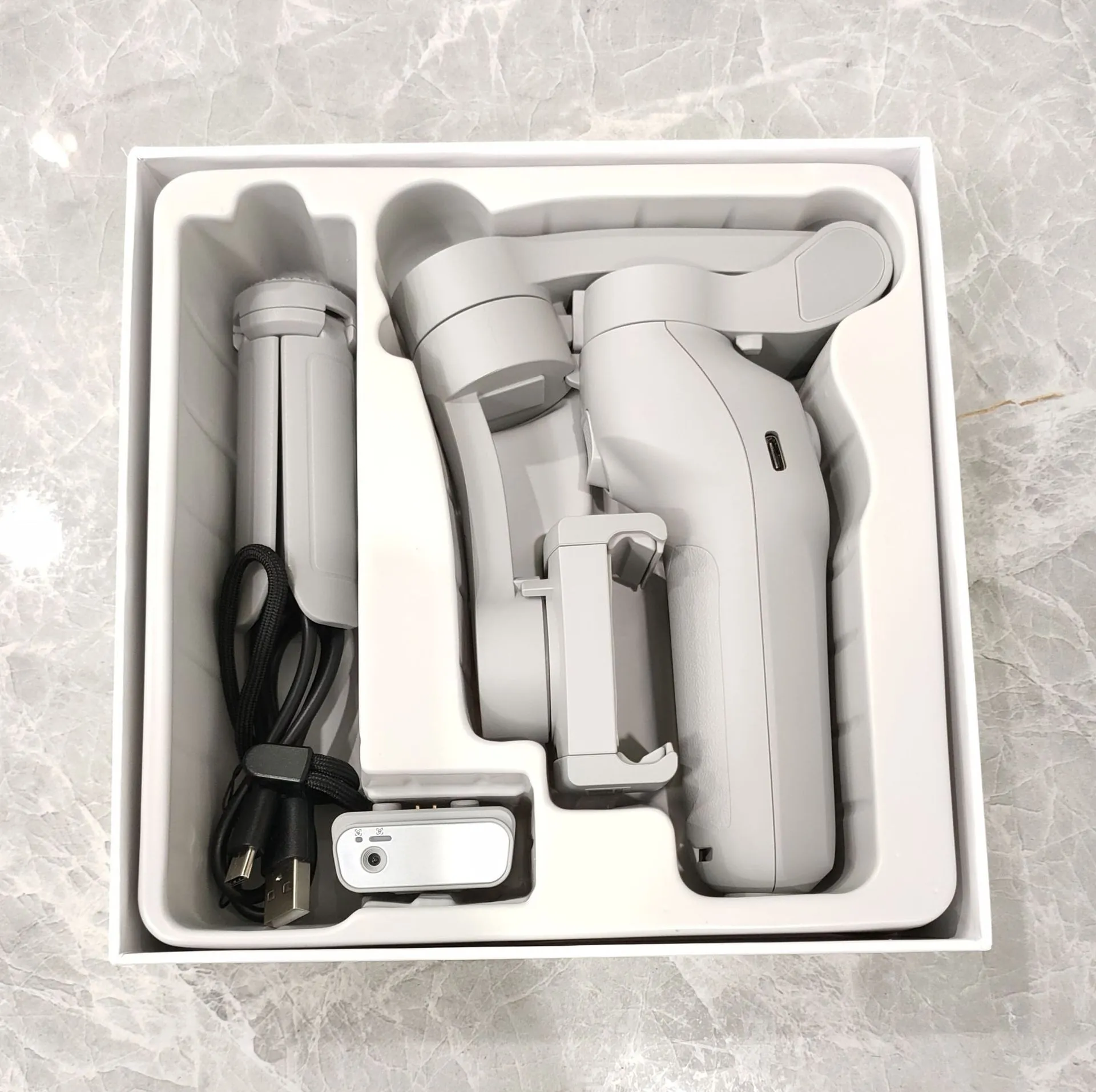 New foldable handheld stabiliser in silver grey for mobile phone with Type-C cable and manual
