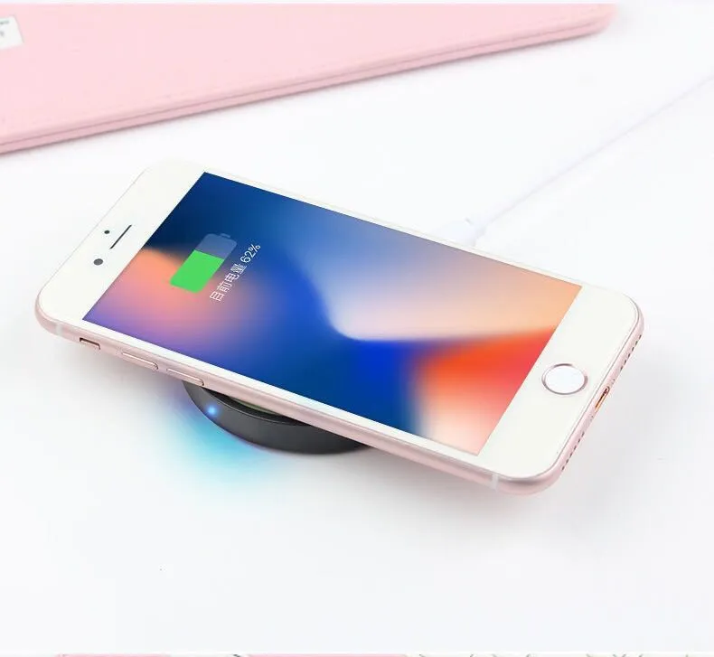Qi wireless charging base for mobile phones in six colours on a wooden table.