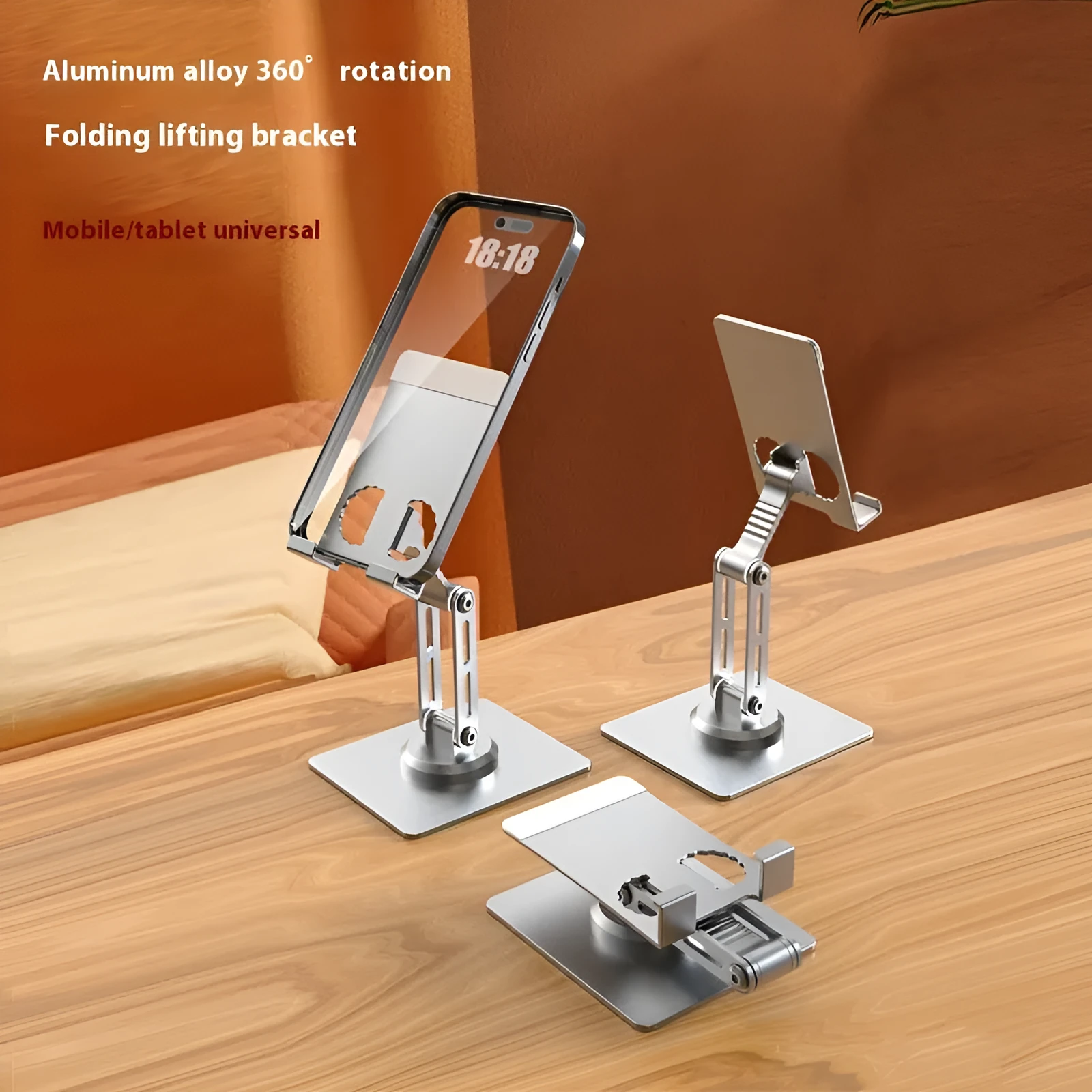 Aluminium alloy rotating mobile phone bracket in silver on a desk, showing three-axis joint and metal texture finish