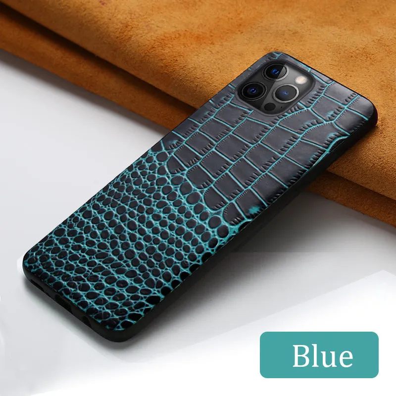 Handmade leather iPhone case with crocodile pattern texture in brown colour on a table.