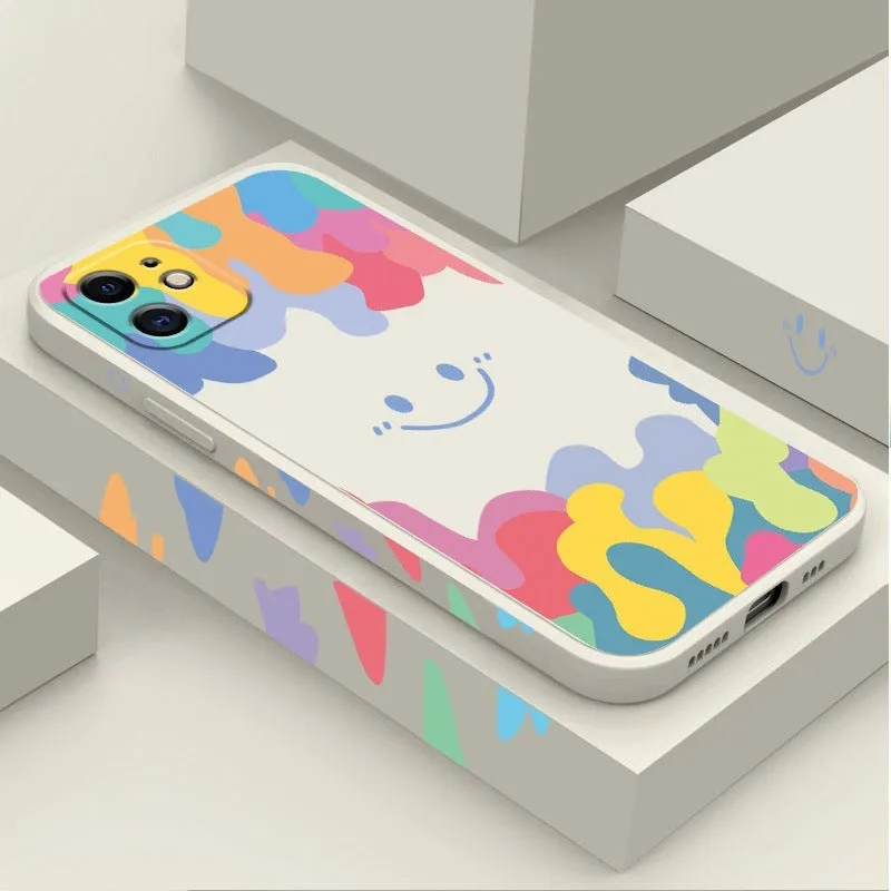 White silicone phone case with a rainbow smiley face design and a black lanyard attached.