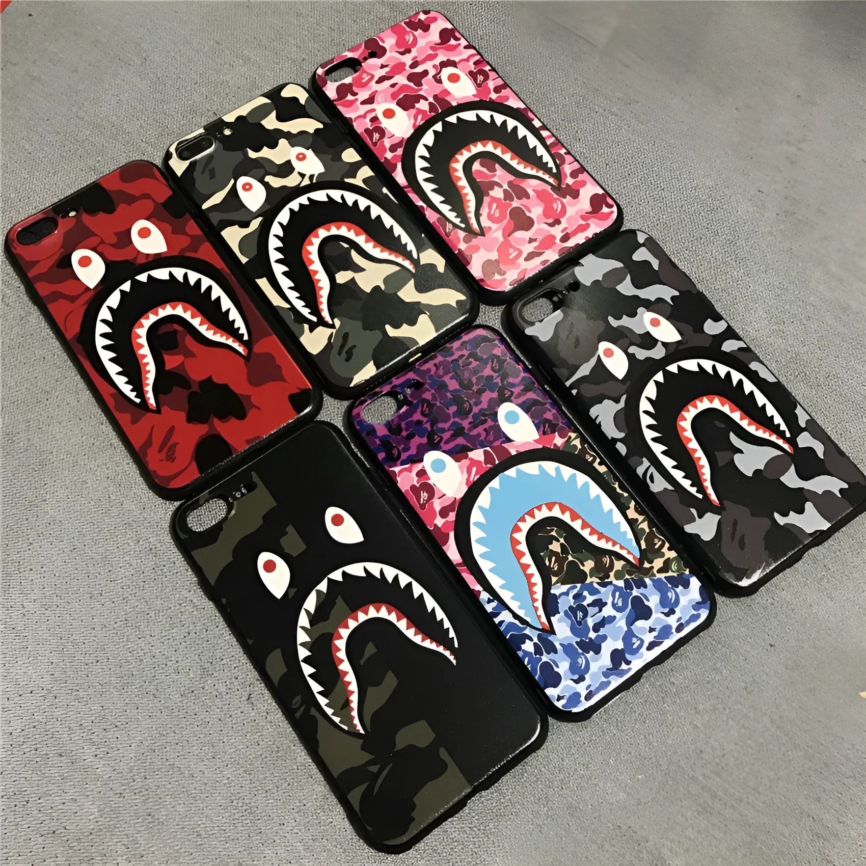 Frosted silicone phone case with shark mouth design in red, green, gray, and pink colours