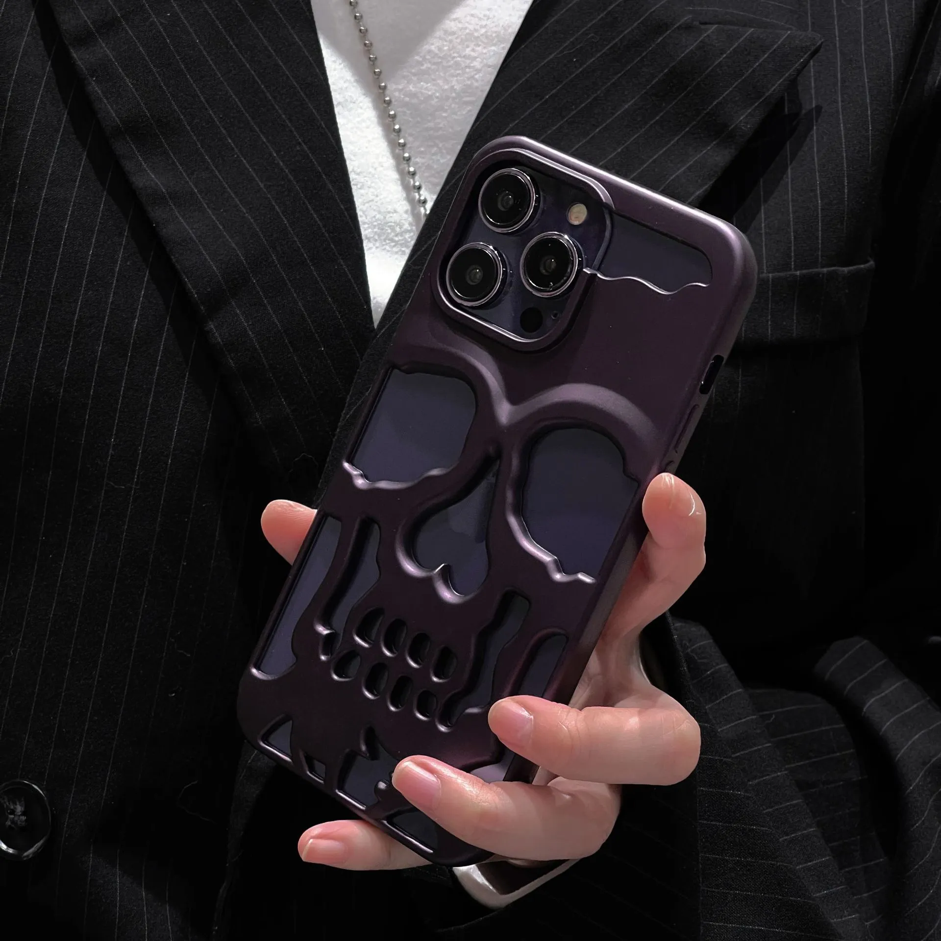 Frosted skull TPU phone case in matte black for iPhone 14 Pro showing hollow skull design