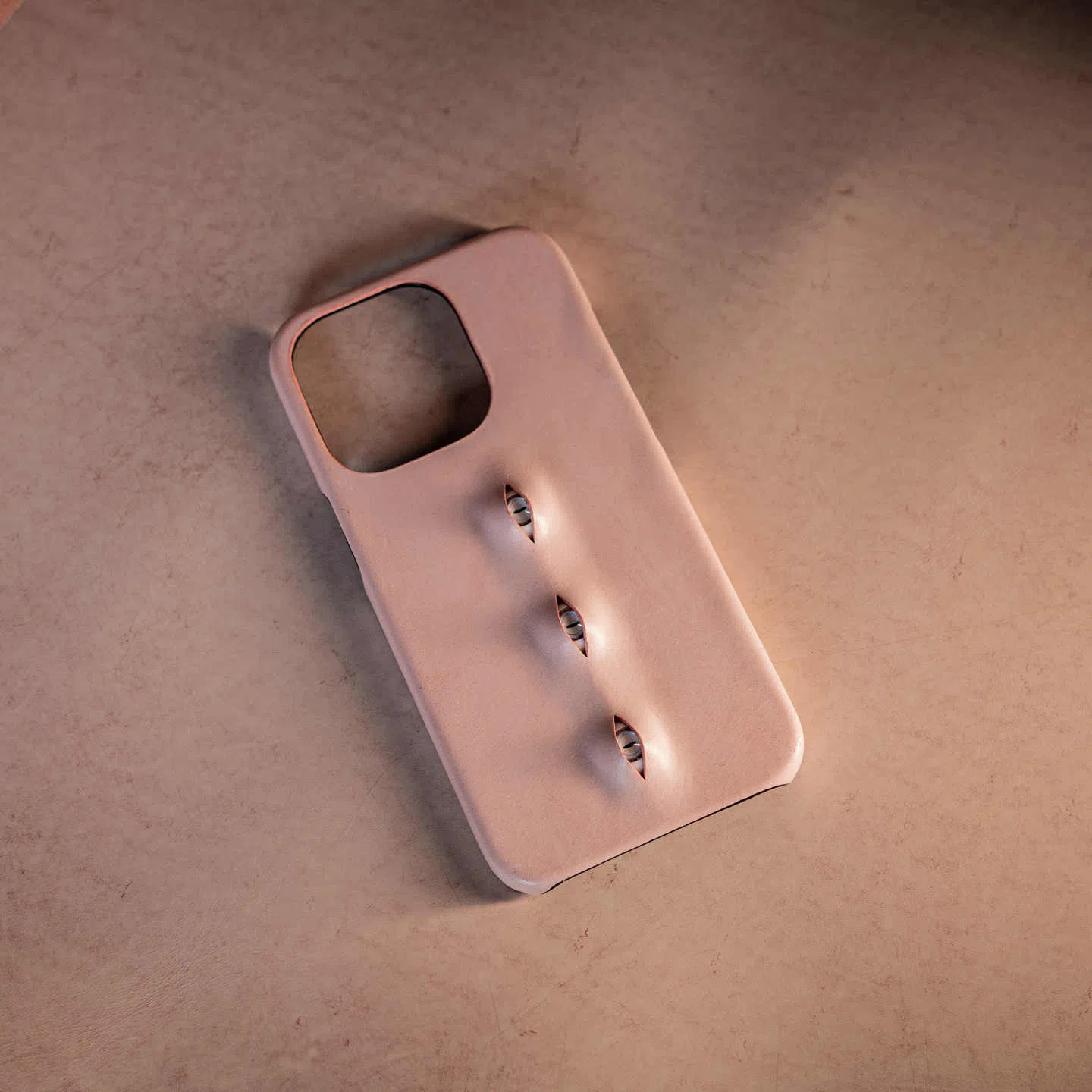 Handmade waxed cowhide leather eye phone case in pink with three-eye vertical design