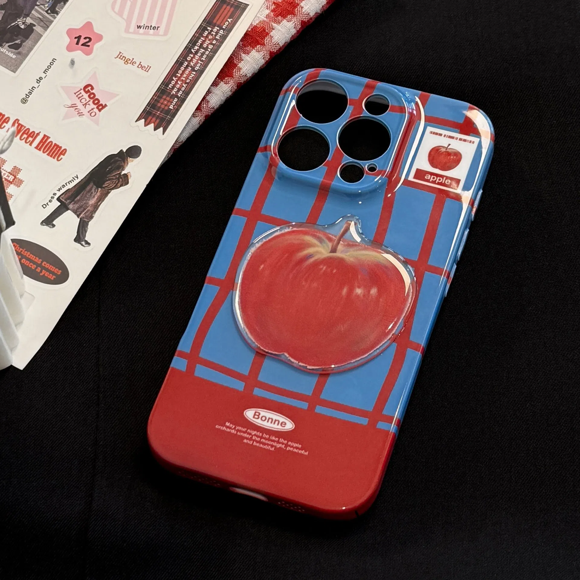 Colour-block checkered 3D fruit phone case for iPhone with blue red grid pattern and red fruit design pendant on a white background