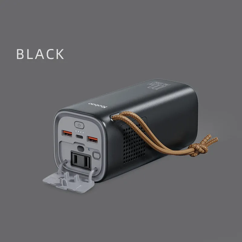Black portable power bank with solar panel, showing size scale and output ports.