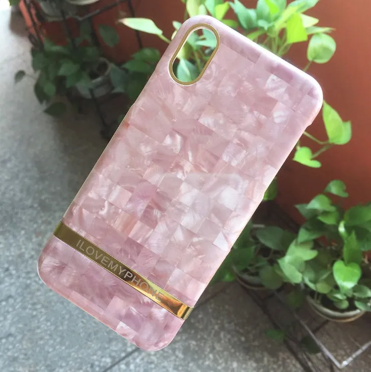 Marble pattern plastic protective case for iPhone in multiple colour options on a dark surface.