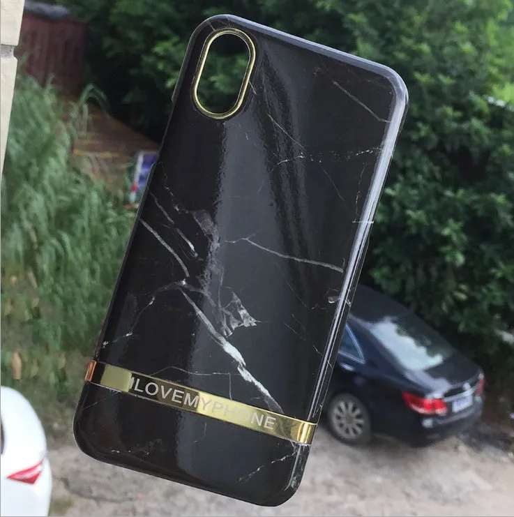 Marble pattern plastic protective case for iPhone in multiple colour options on a dark surface.