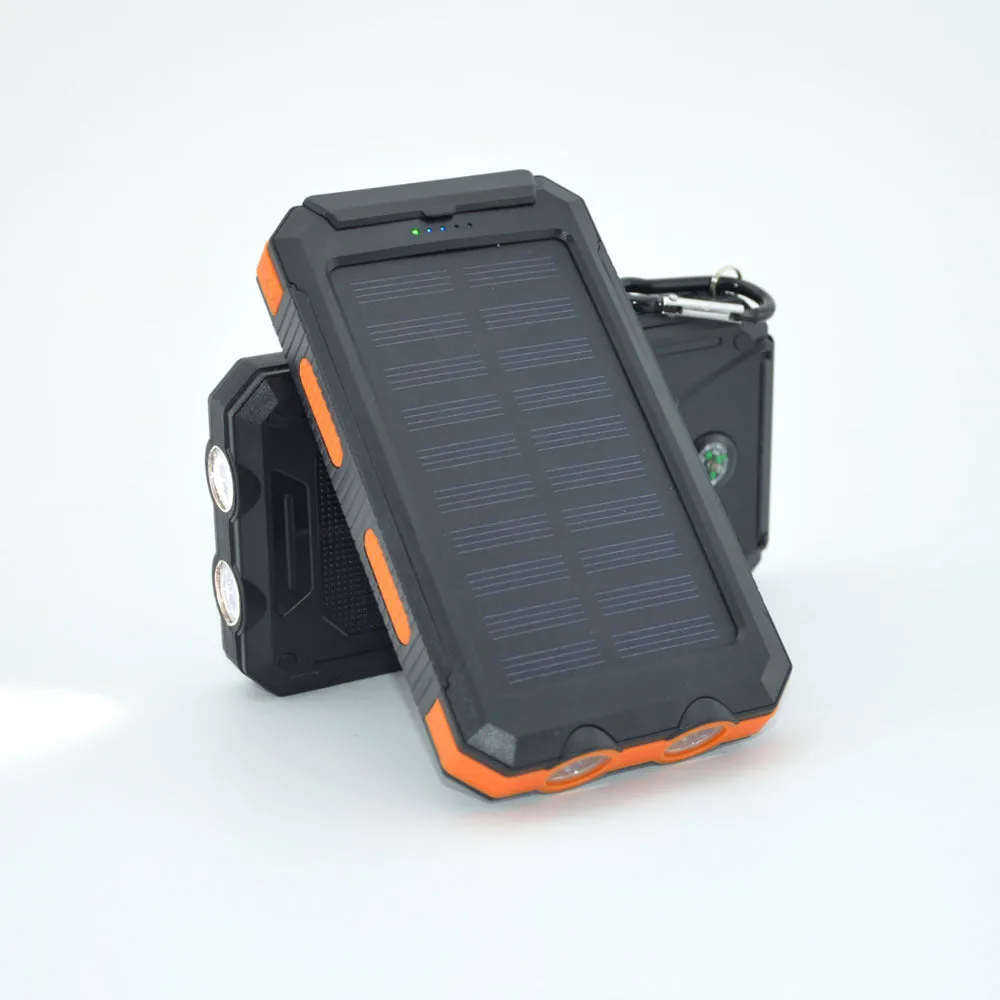 Black solar power bank showing LED flashlight, digital compass display, and solar panel on a rugged outdoor surface.