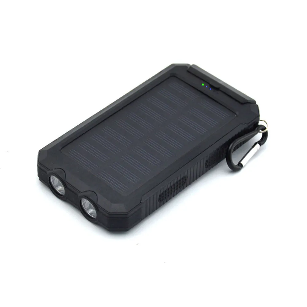 Black solar power bank showing LED flashlight, digital compass display, and solar panel on a rugged outdoor surface.