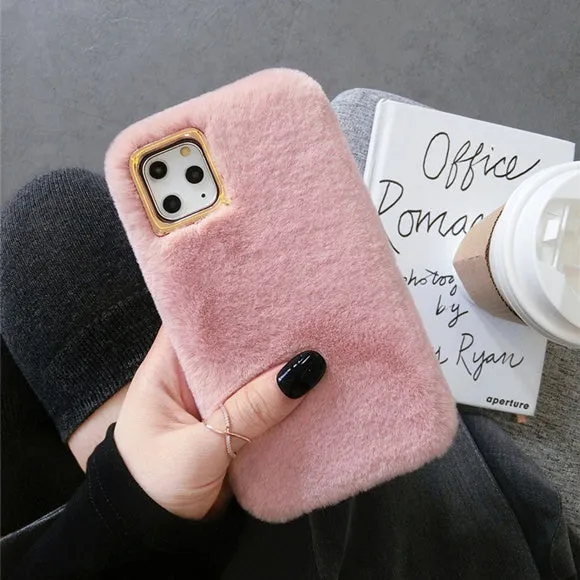 A pink rabbit plush phone case next to a silicone shell, showing the raised camera circle.