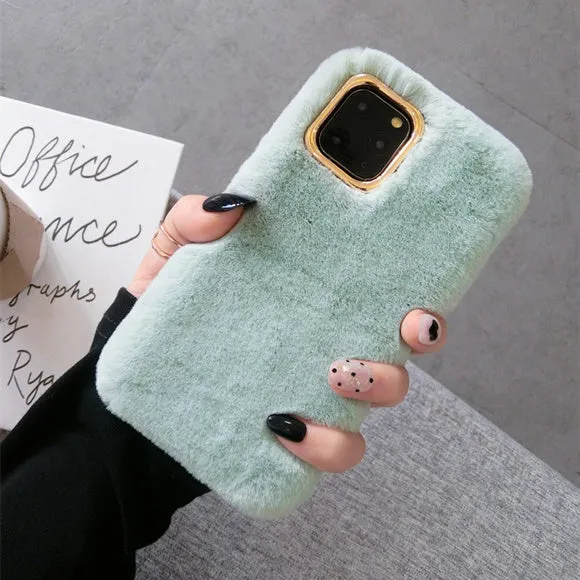 A pink rabbit plush phone case next to a silicone shell, showing the raised camera circle.