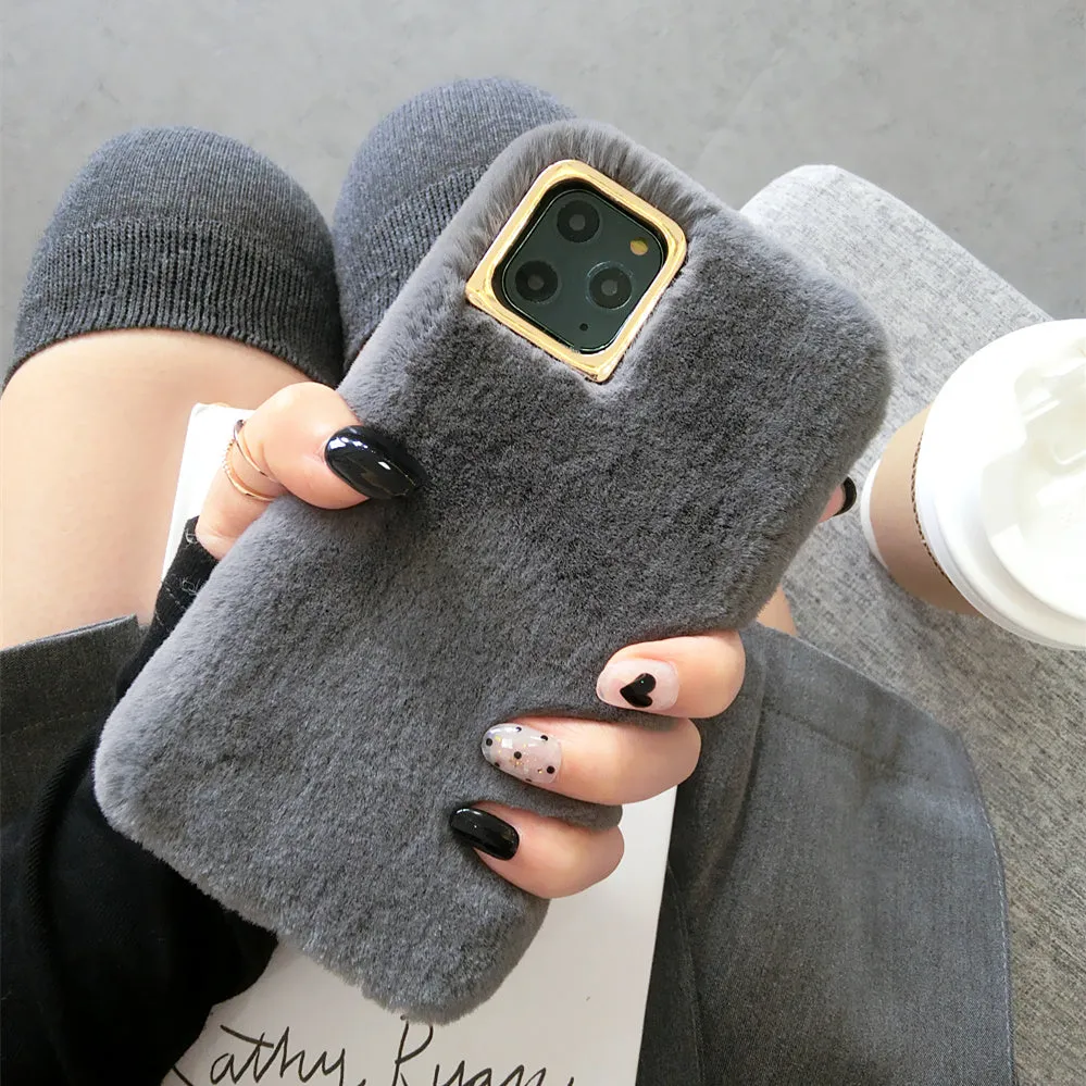 A pink rabbit plush phone case next to a silicone shell, showing the raised camera circle.