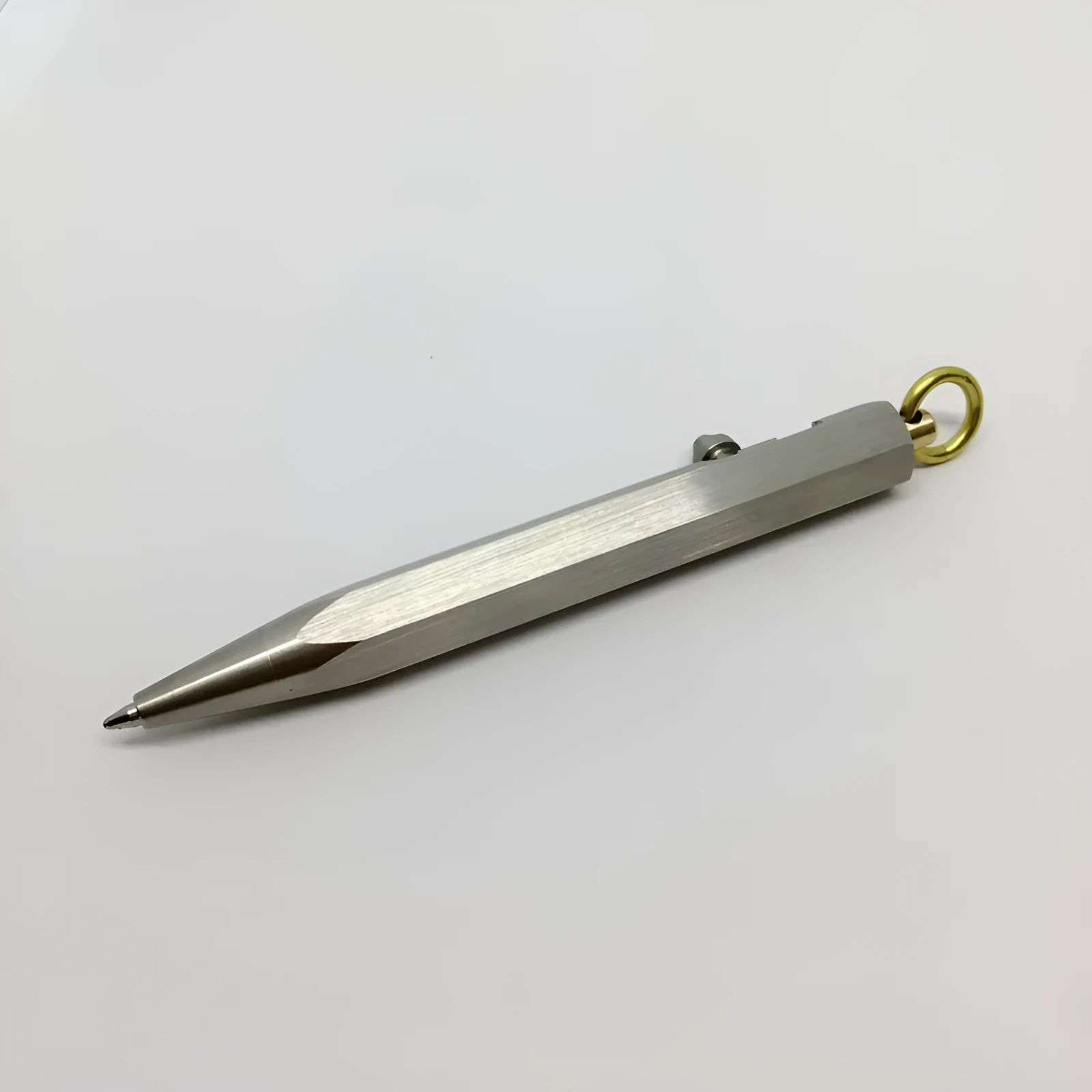 Six-sided stainless steel brass push pen with keychain attachment shown in assorted colours