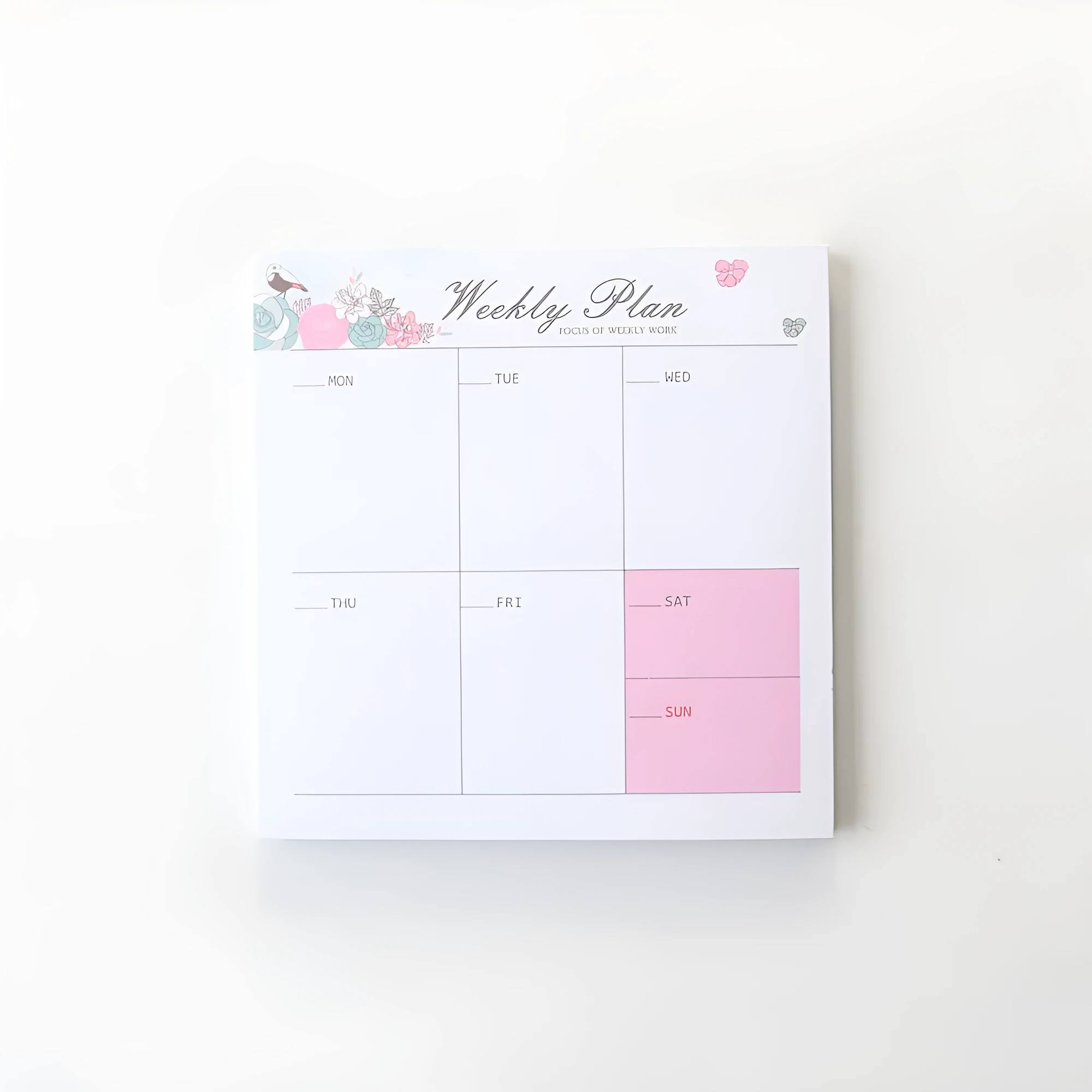 Domikee paper desk organiser pad open showing weekly and monthly planning templates with pink and green cover.