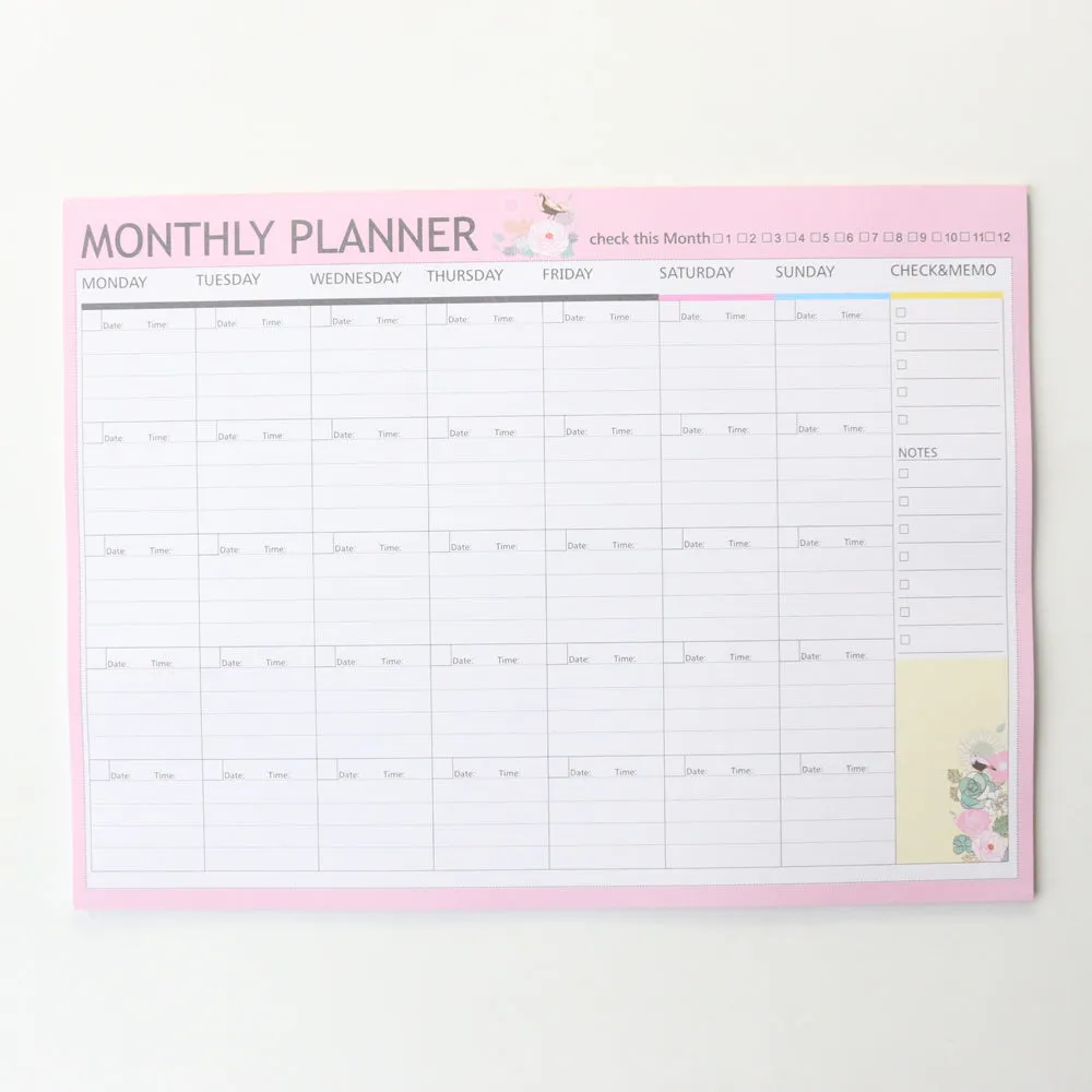 Domikee paper desk organiser pad open showing weekly and monthly planning templates with pink and green cover.