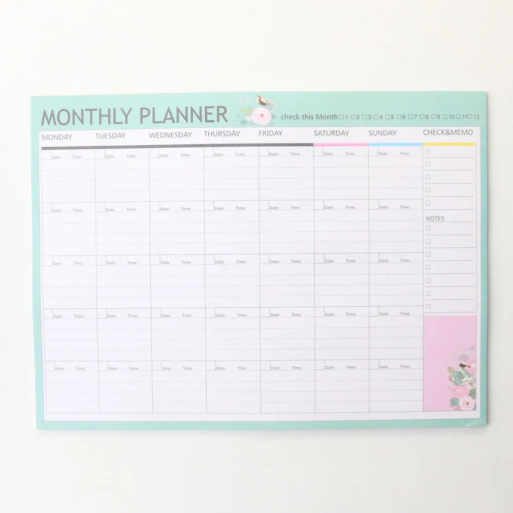 Domikee paper desk organiser pad open showing weekly and monthly planning templates with pink and green cover.