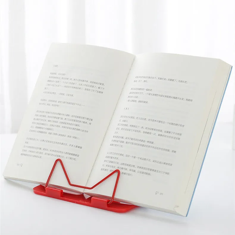 Red reading frame holding a book upright at an angle on a desk