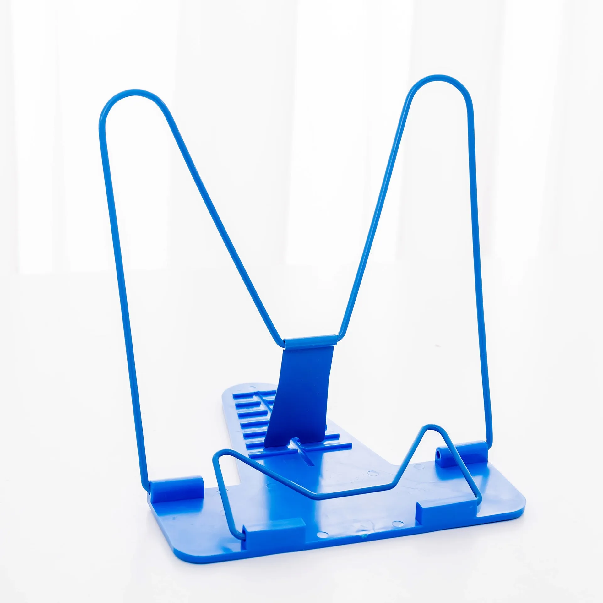 Red reading frame holding a book upright at an angle on a desk