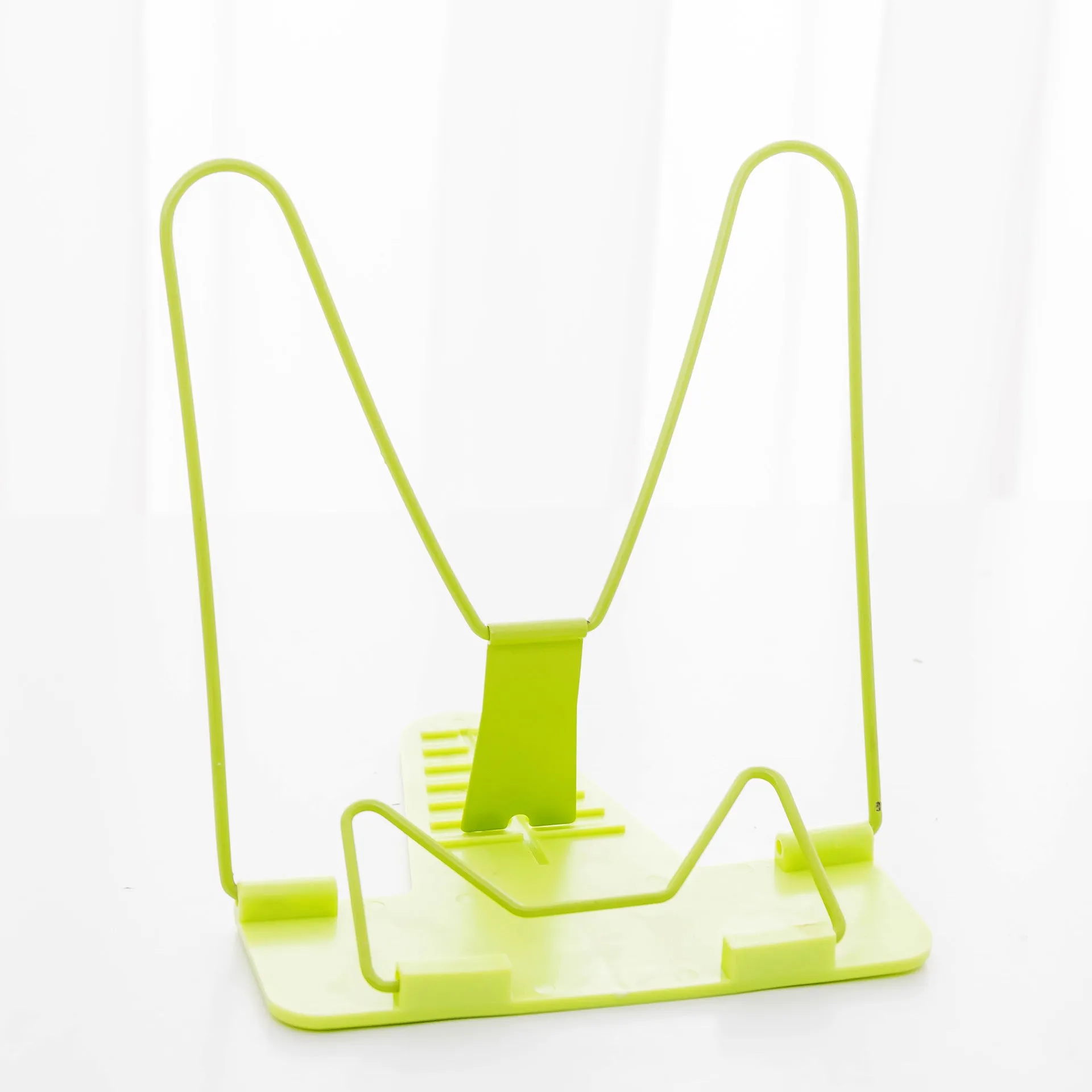 Red reading frame holding a book upright at an angle on a desk