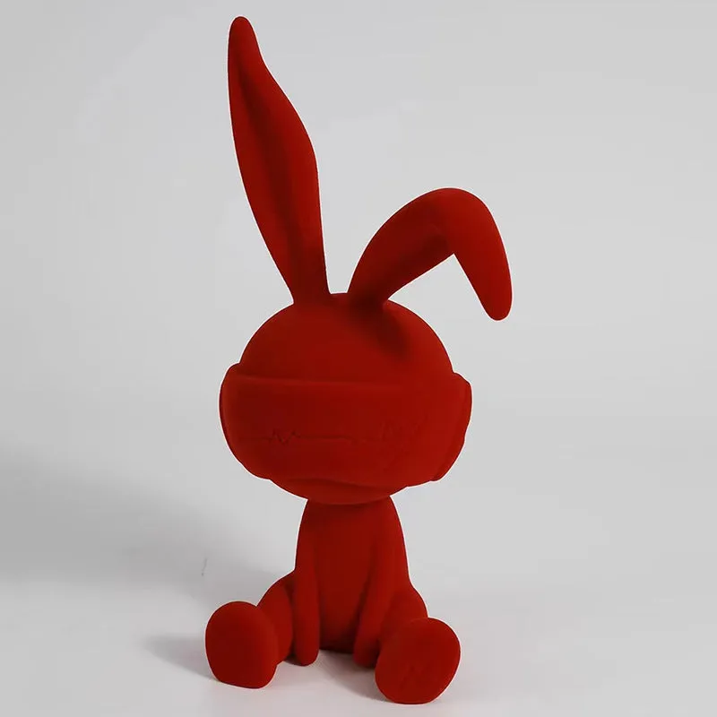 Green suede blindfold rabbit resin ornament seated on a table