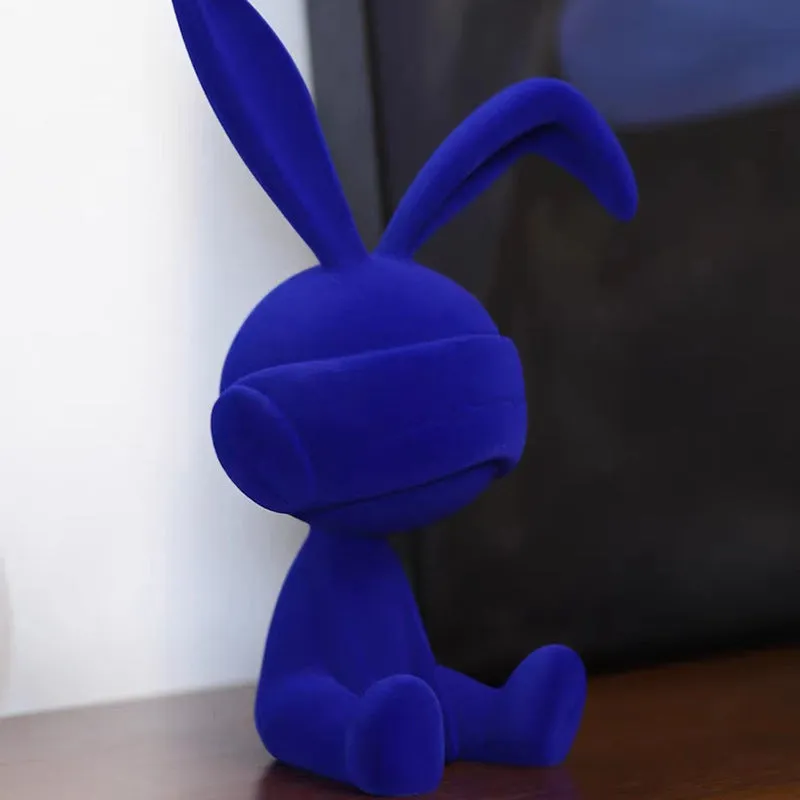 Green suede blindfold rabbit resin ornament seated on a table