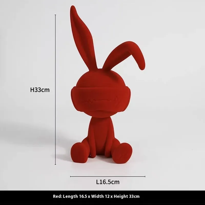 Green suede blindfold rabbit resin ornament seated on a table