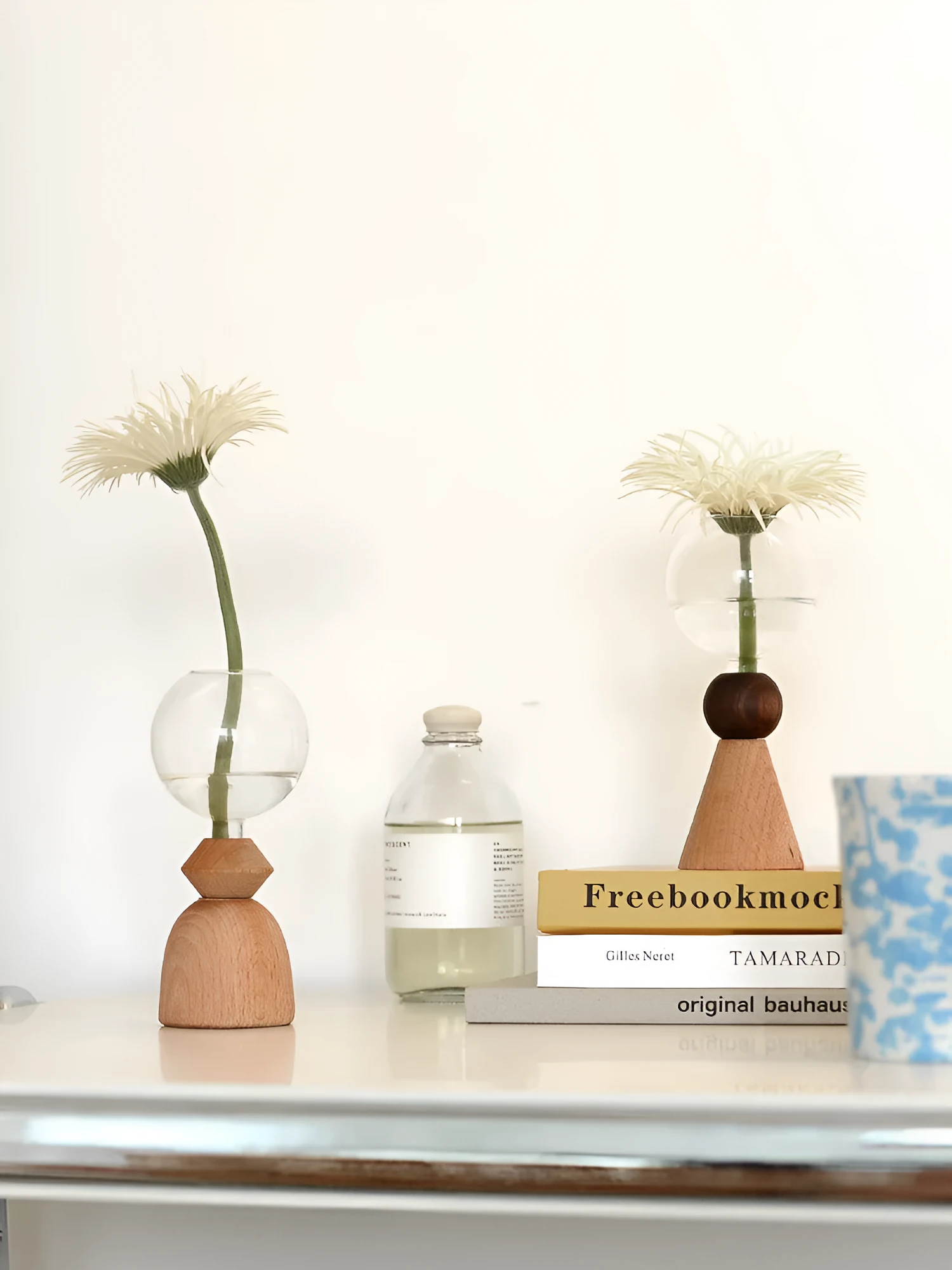 Clear glass Nordic geometric bubble vase with choice of conical base or curved arc base on a wooden table.