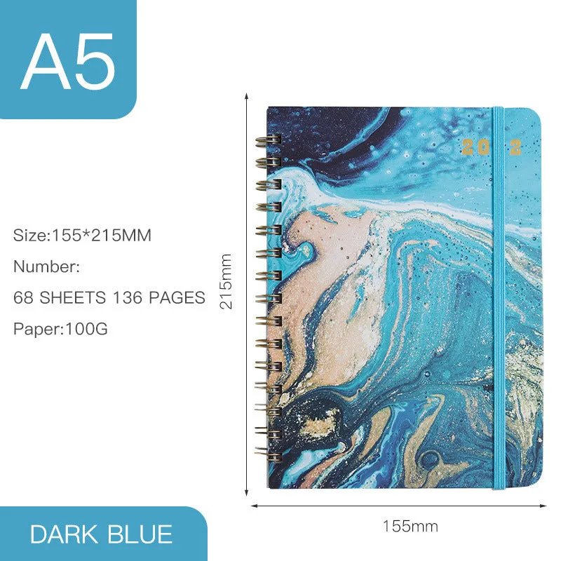 A5 spiral notebook with colourful floral cover, open to show lined pages and metal coil binding