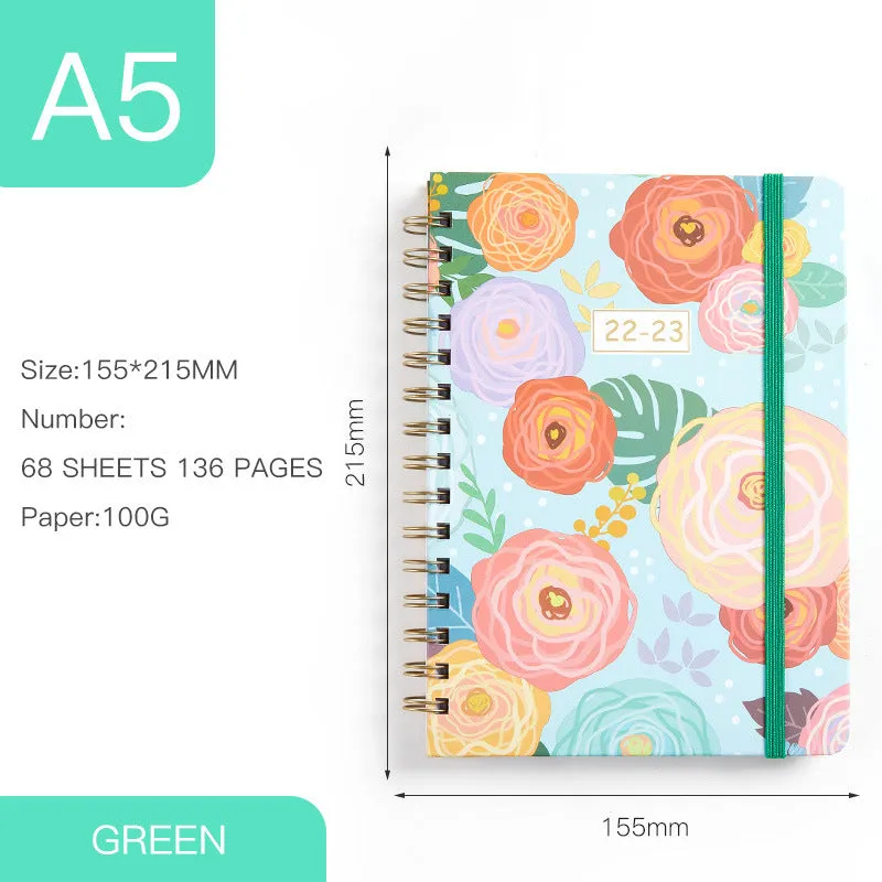 A5 spiral notebook with colourful floral cover, open to show lined pages and metal coil binding