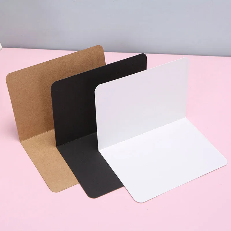 A pack of 100 blank folded kraft paper cards in 10x15cm size, shown in black, brown, and white colours.