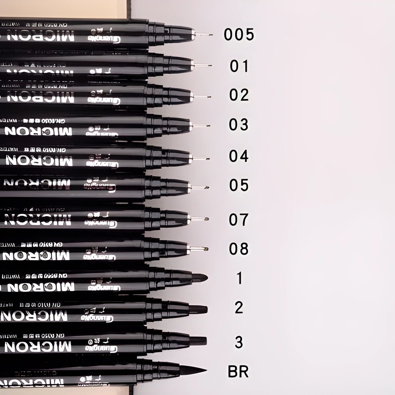 Set of 12 black comic drawing pens with various nib sizes stored in a fabric organiser bag.