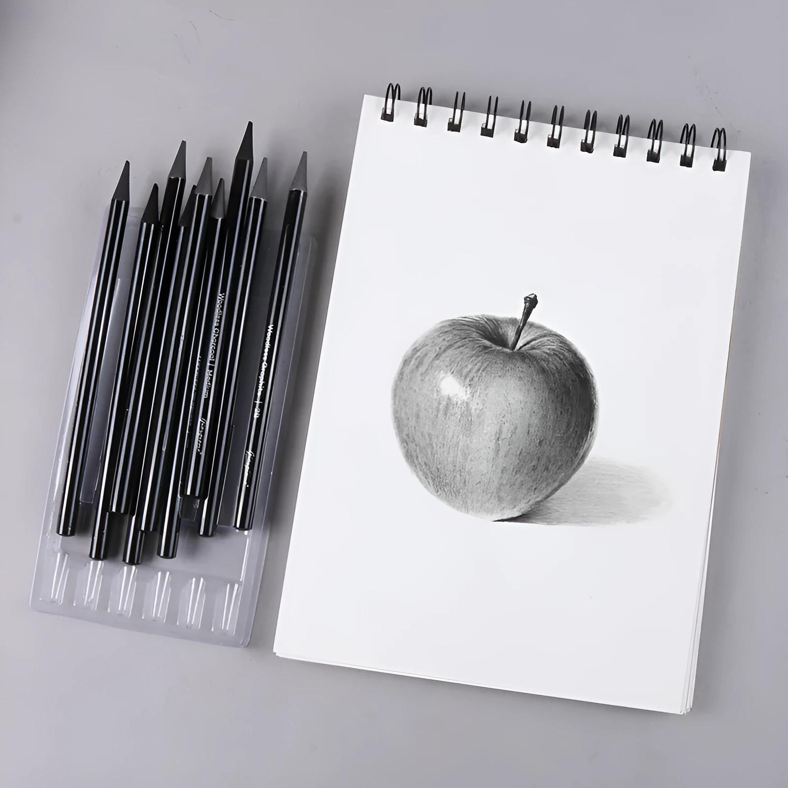 Set of nine graphite and carbonised drawing pencils in wooden casings on a suction card.