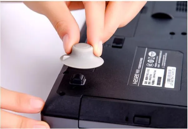 Set of four grey plastic non-slip cooling pads for laptops, two large and two small.