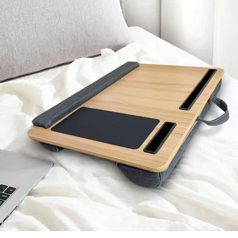 Foldable laptop desk in black walnut colour on a bed with laptop open